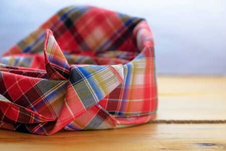 Image of tengkolok known as destar, traditional Malay male headgear on wooden surface. Made from cloth folded and tied in particular style. Worn in ceremony. Selective focus only.の写真素材