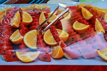 Slices of fresh watermelon and orange on a white plate