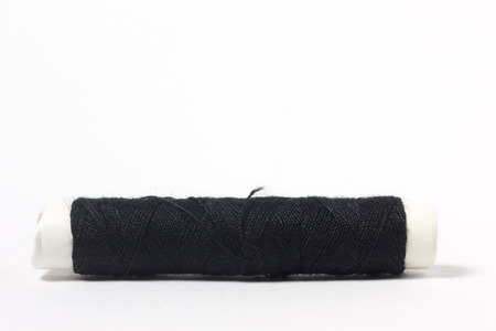 Black cotton thread on a white backgroundの写真素材