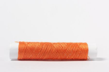 Orange cotton thread on a white background