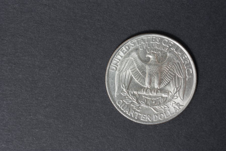 A quarter of the US dollar on the black background