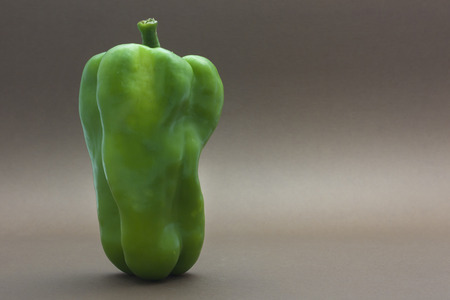 Green pepper isolated on a brown background to understand a concept to healthy eatingの写真素材
