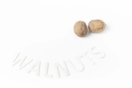 Two walnuts on a white background with the inscription wood