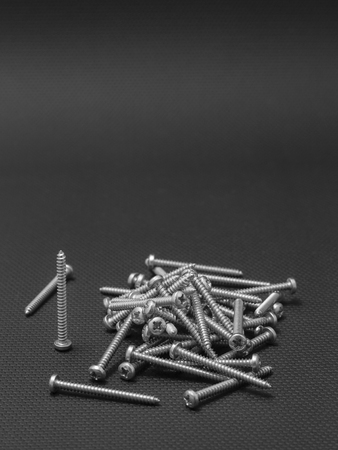 Screws located on a black background to understand an industrial conceptの写真素材