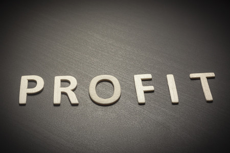 Profit written with wooden letters on a gray background to understand a concept of economics and financeの写真素材
