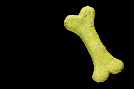 Dog biscuit on black background to connote a concept of feeding animalsの写真素材