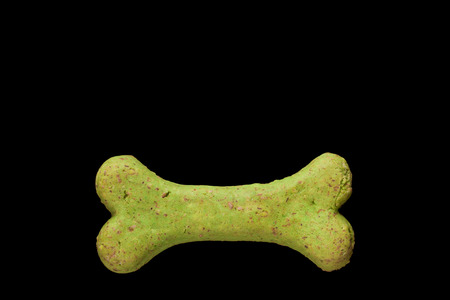 Dog biscuit on black background to connote a concept of feeding animalsの写真素材