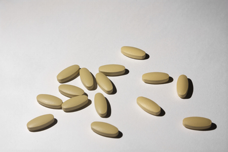 Pills of brown color on white background to mean a medical business conceptの写真素材