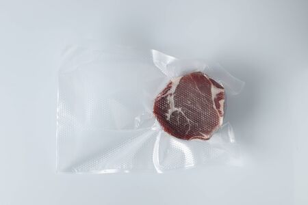 Smoked pork meat in vacuum package isolated on white backgroundの写真素材
