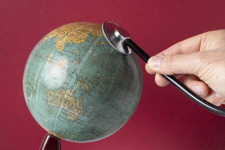 world globe with stethoscope on red background to mean an environment conceptの写真素材