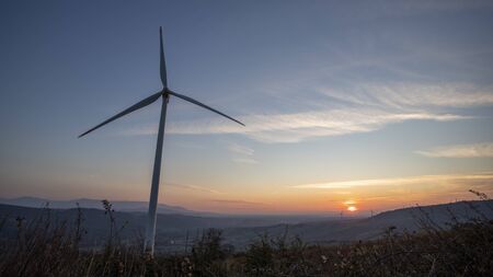 Silhouette wind turbines at sunset backgroundの写真素材