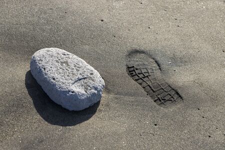 A footprint on the beach while the sun is setting. Warm tropical colors