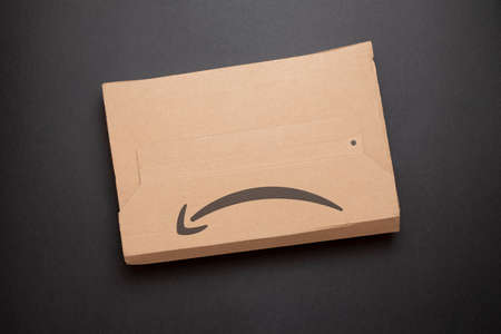 Salerno, Italy - February 26, 2020: Amazon logo on a delivered package isolated on a black background. Amazon is an online retailerのeditorial素材