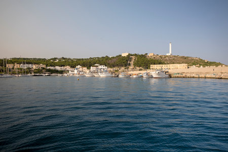 Lighthouse overlooking the bay of Santa Maria di Leuca with cityscape, ship on the ocean, clear skyのeditorial素材