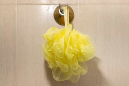 Yellow soft bath puff or used shower sponge.の写真素材