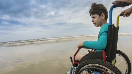 Child in wheelchair horizon sand footの写真素材