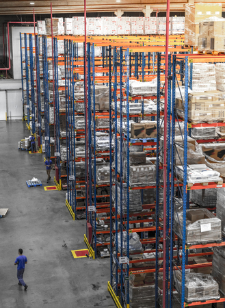 Logistic shed and distribution boxes workers and forklift in operationの写真素材