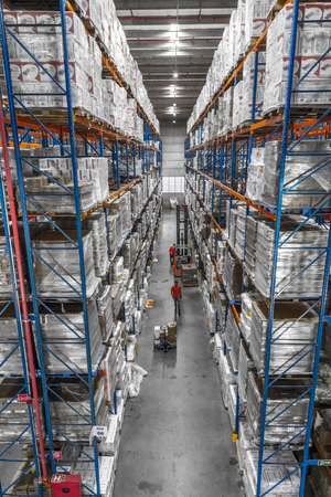 Logistic shed and distribution boxes workers and forklift in operationの写真素材