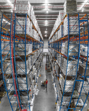 Logistic shed and distribution boxes workers and forklift in operationの写真素材