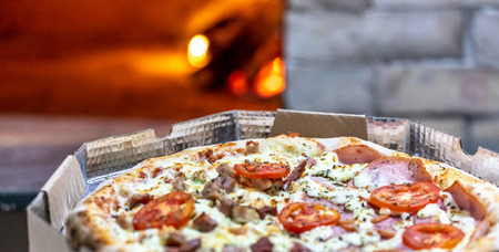 Delicious pizza being roasted in traditional wood ovenの写真素材