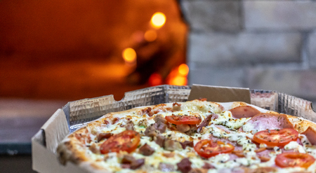 Delicious pizza being roasted in traditional wood ovenの写真素材