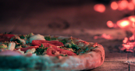 Delicious pizza being roasted in traditional wood ovenの写真素材