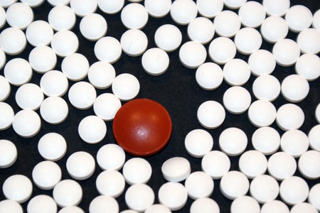 Many white pills and one redの写真素材