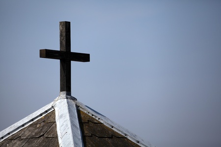 Cross on top of chapel against grey skyの写真素材