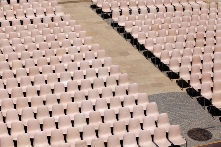 Many light rosa chairs lined up for concert, speach or other eventの写真素材