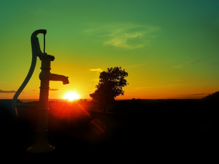 Old water pump  Sunset over the horizon of the sea の写真素材