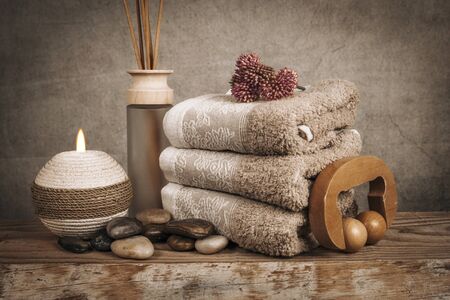 Spa essentials, aroma sticks, stones, towels, sea shell on a wooden rustic backgroundの写真素材