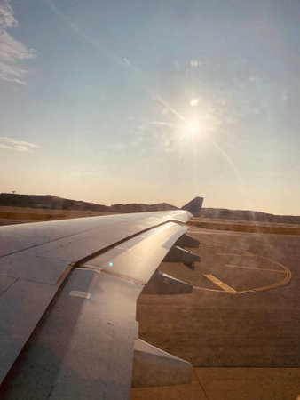 View of the wing of an airplane flying over the airport in Spainの写真素材