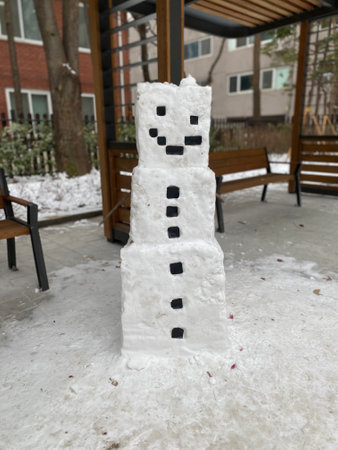Snowman made of snow in the yard of a residential building.