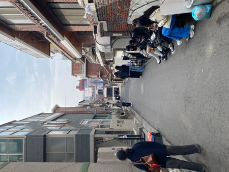 Unidentified people walk on the street.