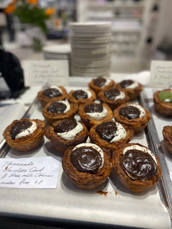 Chocolate tartlets with whipped cream on display in a shop window