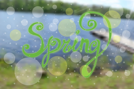 inscription Spring is a black gel pen. Inscription with curls on blurred background of a summer landscape with a small river, treesのイラスト素材