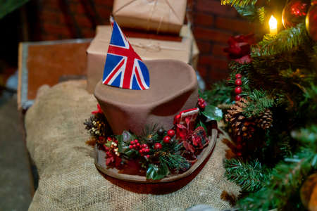 A hat with a British flag on the background of the Christmas tree.