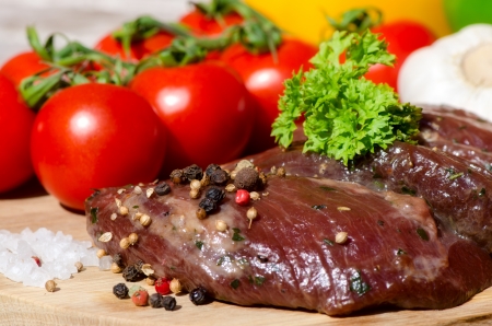 meat with fresh vegetables on wooden boardの写真素材