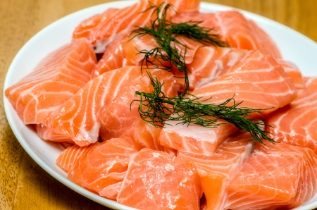 fresh salmon with dill on white plateの写真素材