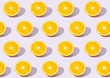 Colorful seamless pattern of fresh orange. Fruit concept on a pastel purple background. Summer...