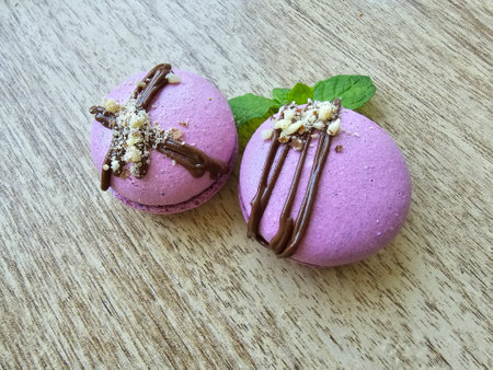 Macaroons with chocolate and mint leaves on wooden table. Toned.の写真素材