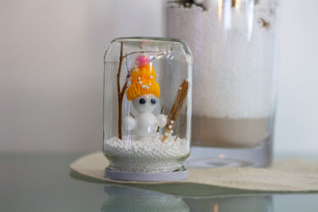 snowman in a glass jar on a glass table, christmas decorationの写真素材