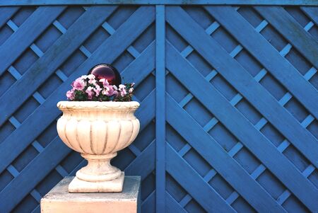 Blue Fence with White Flower Tubの写真素材