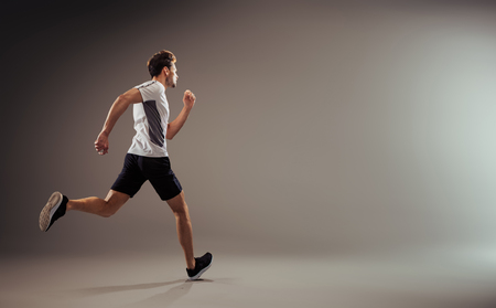 Young and active jogger running  - isolatedの写真素材