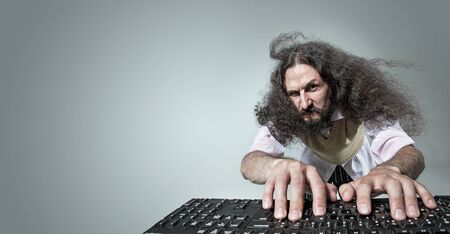 Funny portrait of a freaky nerd working with a computerの写真素材
