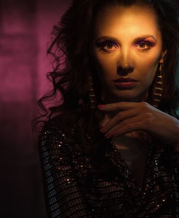 Closeup portrait of a pretty young woman posing in the nightclubの写真素材