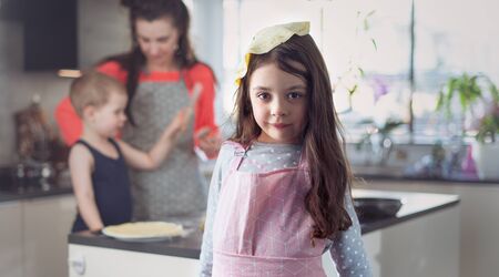 Cheerful family making delicious crepes in the home kitchenの写真素材