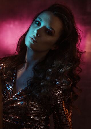 Closeup portrait of a pretty young woman posing in the nightclubの写真素材