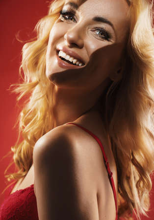 Portrait of an alluring blonde wearing the red, lace underwearの写真素材