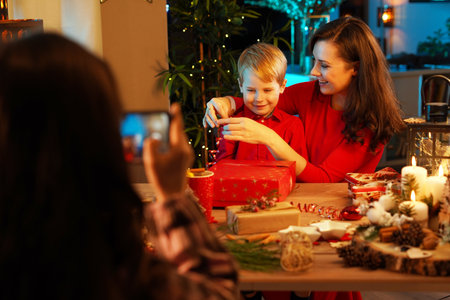 Cheerful, little daughter taking a picture of her mother and brother - Christmas conceptの写真素材
